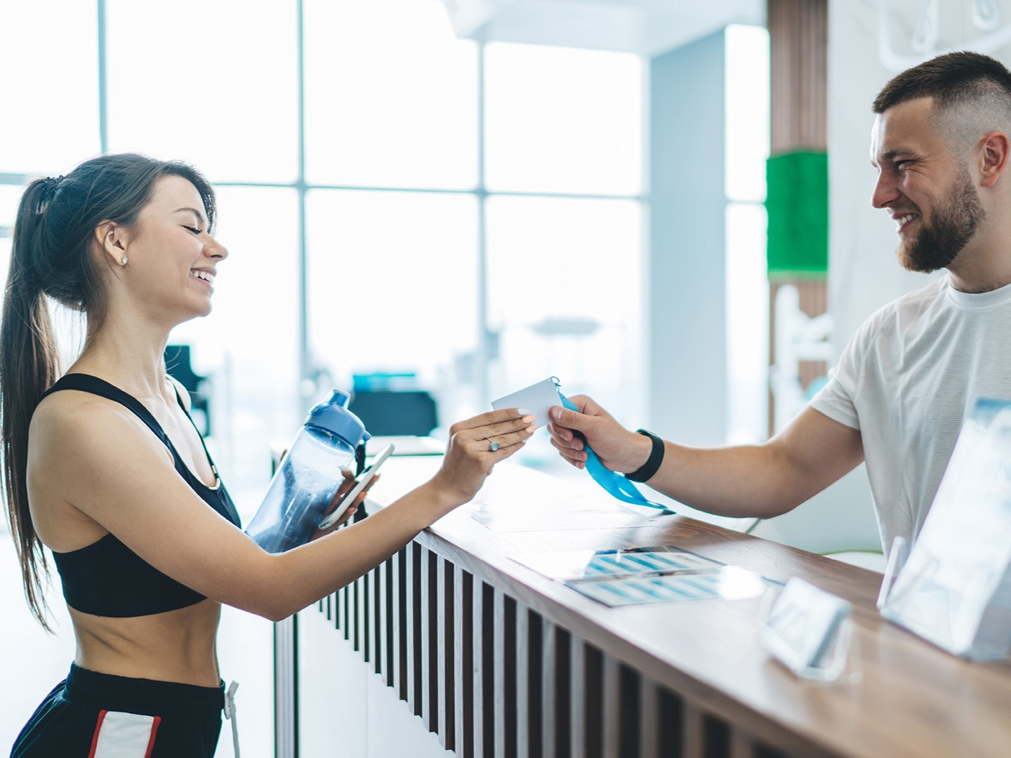 Receptionist porge card per controllo accessi in palestra a un'iscritta